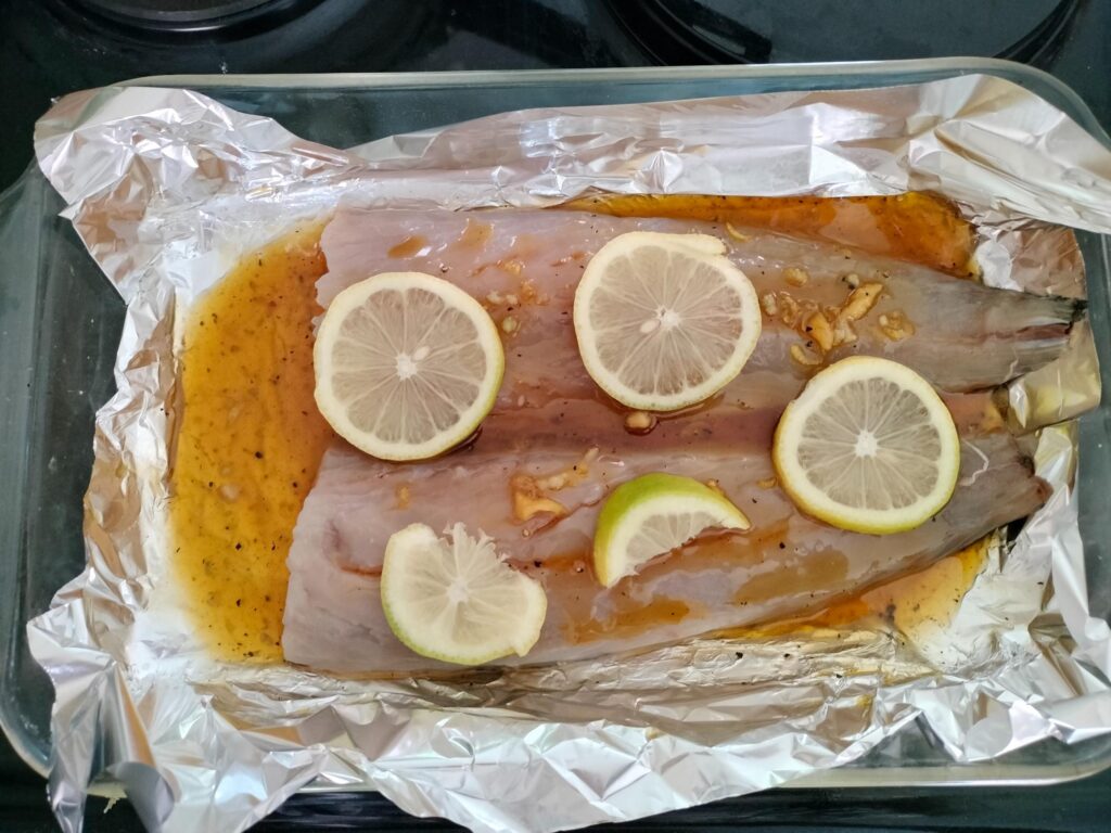 raw snoek on foil with lemon slices on top